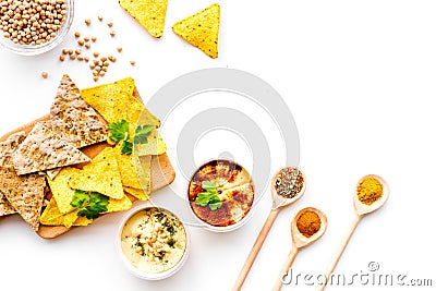 Cooking chickpeas. Bowl with hummus among pieces of crispbread and spices on white background top view copy space Stock Photo