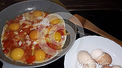 Cooking the classic Israeli food shakshuka from tomatoes and eggs Stock Photo