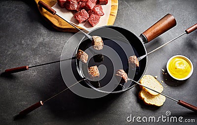 Cooking Cubes of Beef in Fondue Pot of Hot Oil Stock Photo