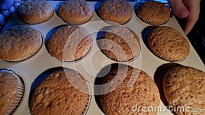 Cooking cupcakes at home. Beautiful girl in kitchen remove muffins from oven stock video Cooking cupcakes at home. Beautiful girl in kitchen remove muffins from oven stock video