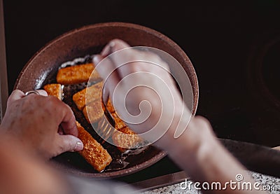 Cooking delicious fish fingers in pan Stock Photo