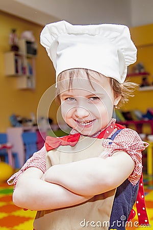 Cooking fever. Humorous portrait of cute child girl chef. Stock Photo