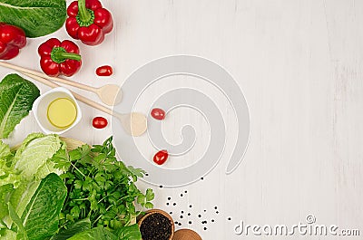 Cooking fresh spring salad of green and red vegetables, spices on white wooden background, border, top view. Stock Photo