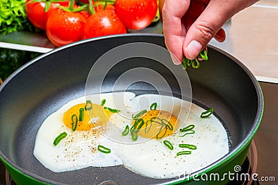 cooking fried scrambled eggs, hands with a wooden spatula Stock Photo