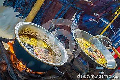 Cooking on a frying pan a dough for chapati on Manmandir ghat on the banks of the holy river Ganges in Varanasi on blue Stock Photo