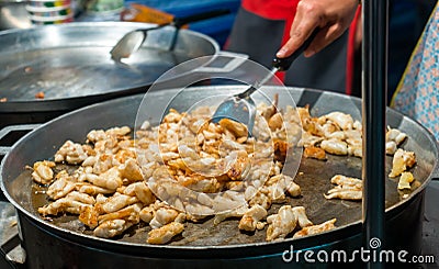 Cooking frying squid with egg in a big pan at market stall Stock Photo