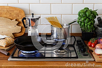 Cooking meal on a gas stove in traditional home kitchen. Wood worktop. Stock Photo