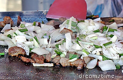 Cooking Meat and Onions on a Griddle Stock Photo