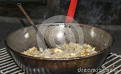 Cooking migas or Crumbs a typical spanish food. Crumbs prepared in a frying pan Stock Photo