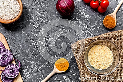 Cooking paella with vegetables and rice on dark desk background top view mockup Stock Photo