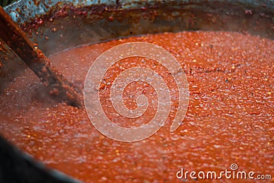 Cooking red bell peppers, tomatoes, eggplants over a fire to make national delicious Bulgarian lyutenitsa tomato sauce. Stock Photo