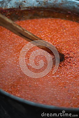 Cooking red bell peppers, tomatoes, eggplants over a fire to make national delicious Bulgarian lyutenitsa tomato sauce. Stock Photo