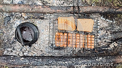 Sausages deliciously barbecued over open charcoal fire using carved wooden sticks Stock Photo