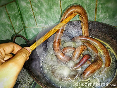 Blood sausage preparation process by boiling. Stock Photo