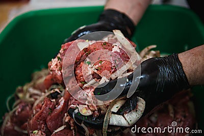 Cooking skewers of pork, mixing pieces of meat with marinade, onions. Stock Photo