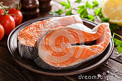 Cooking two fresh raw salmon fish steaks on wooden rustic table Stock Photo