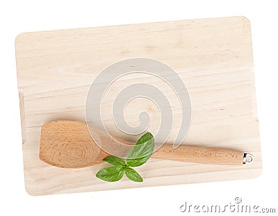 Cooking utensil and basil leaves over cutting board Stock Photo