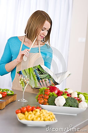 Cooking - Woman reading cookbook in kitchen Stock Photo