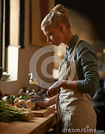 Cooking, woman and vegetables with knife in home with diet, nutrition and food with turnip. Kitchen, green and health Stock Photo