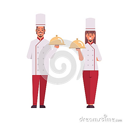 Cooks couple professional chefs holding covered platters serving trays woman man restaurant workers in uniform standing Vector Illustration