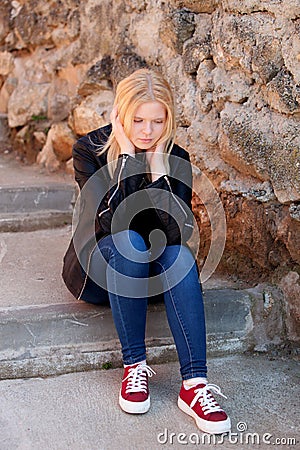 Cool blonde girl sitting outdoor Stock Photo