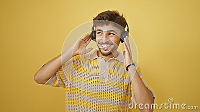 Cool, confident young arab man grooving to music on his headphones Stock Photo
