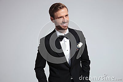 Cool elegant man in tuxedo is laughing while looking away Stock Photo