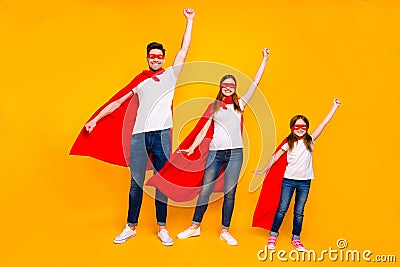 Cool family play cartoon characters protect world fly up air wear superhero coats isolated yellow background Stock Photo