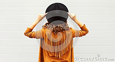 Cool girl view from back wearing a black hat, sunglasses and jacket Stock Photo