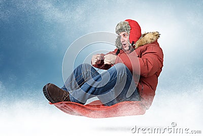 Cool man fly on a sled in the snow Stock Photo