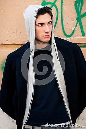 Cool man model with hoodie, urban wall background Stock Photo