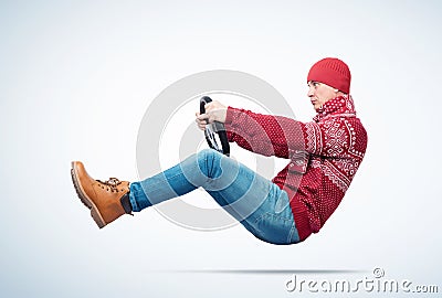 Cool man in a red sweater, scarf and hat drives a car in the hands of a steering wheel. Auto driver concept Stock Photo