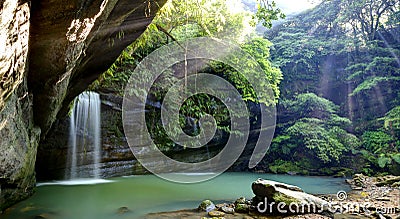 A cool refreshing waterfall into an emerald pond hidden in a mysterious forest of lush greenery ~ River Scenery of Taiwan Stock Photo