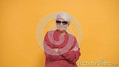 Cool senior woman with gray short hair and sunglasses and crossed hands. Isolated Stock Photo