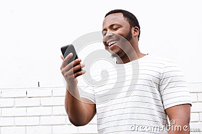 Cool smiling young black man looking at mobile phone Stock Photo