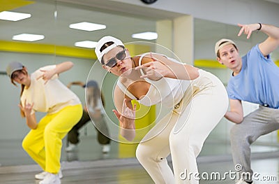 Group of young confident teenagers in casual clothes dancing together during exercise in class Stock Photo