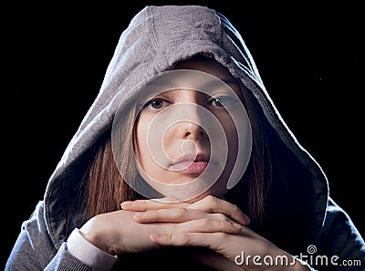 Cool teenager girl or young woman on her 20s posing cool showing attitude wearing hood on Stock Photo