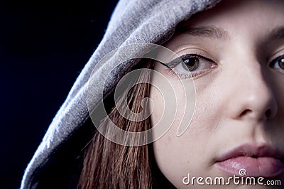 Cool teenager girl or young woman on her 20s posing cool showing attitude wearing hood on Stock Photo