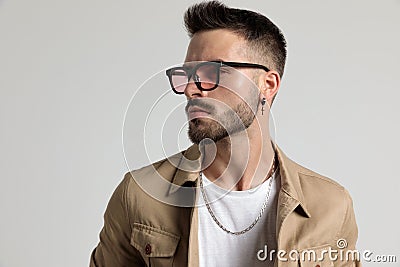 Cool unshaved fashion guy in jacket looking to side Stock Photo