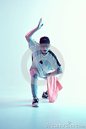 Cool young breakdancer guy in studio in neon light. Dance school poster. Battle competition announcement Stock Photo