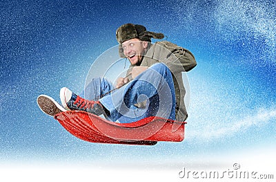 Cool young man fly on a sled in the snow Stock Photo