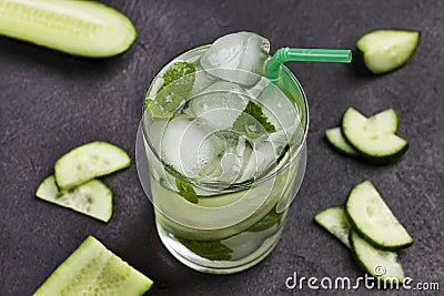 Cooling summer drink with ice and slices of cucumber. Mint and chopped cucumber Stock Photo