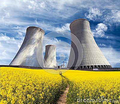 Cooling tower with golden flowering field of rapeseed Stock Photo