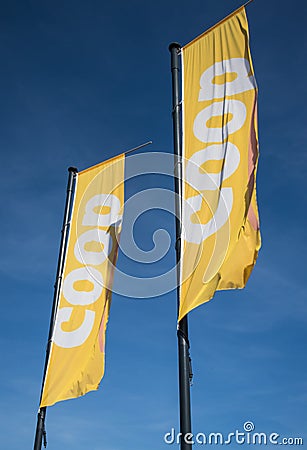 Coop food grocery store flags with branding and logo against a blue sky Editorial Stock Photo