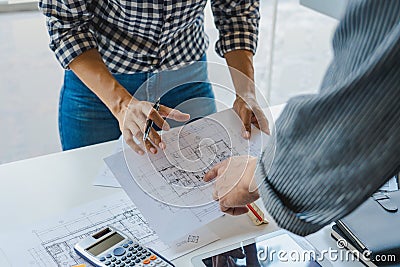 Cooperation Corporate designers in the office are working on a new project Planning blueprint Design at construction site at desk Stock Photo
