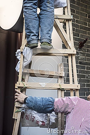 Cooperation, a hand rubbing a wooden ladder, a foot standing on a wooden ladder, Stock Photo