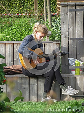 Girl tuning guitar in Copenhagen Editorial Stock Photo