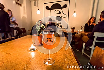 Craft beer bar with drinking people with glasses by danish Mikkeller brewery, with special design Editorial Stock Photo