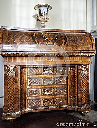 Ornate wooden antique cabinet with patterns and golden inlays Editorial Stock Photo