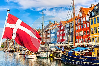 Copenhagen iconic view. Famous old Nyhavn port in the center of Copenhagen, Denmark during summer sunny day with Denmark flag on Editorial Stock Photo